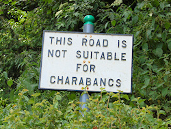 An old road sign warning that a narrow road is unsuitable for charabancs.