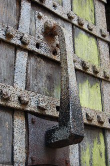 A close-up of an ancient studded door, with a heavy door knocker.